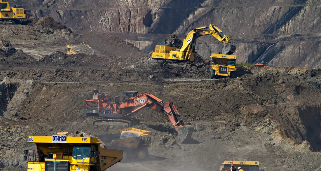Chrome ore stockpile with rail wagons at sunset